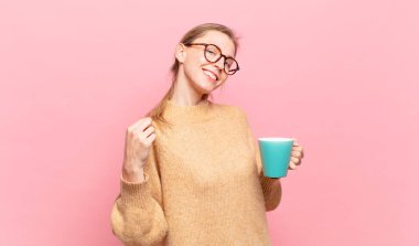 Genç sarışın kadın kibirli, başarılı, pozitif ve gururlu görünüyor, kendini işaret ediyor. kahve konsepti