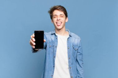 Neşeli, kaygısız, asi tavırlı, şaka yapan ve dilini çıkarıp eğlenen genç bir çocuk. telefon kavramı