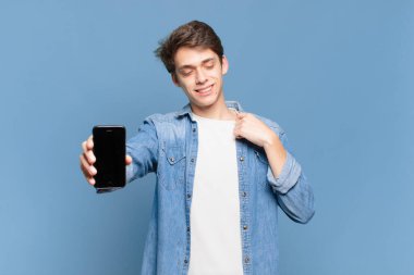 Genç çocuk stresli, endişeli, yorgun ve hayal kırıklığına uğramış, gömleğini çekmiş, sorunlu görünüyor. telefon kavramı