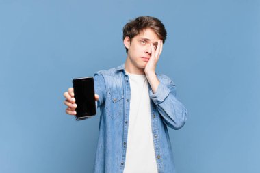 Sıkılmış, hayal kırıklığına uğramış ve uykulu hisseden genç bir çocuk yorucu, sıkıcı ve can sıkıcı bir görevden sonra, el ele tutuşarak. telefon kavramı