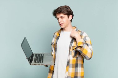 Genç çocuk stresli, endişeli, yorgun ve hayal kırıklığına uğramış, gömleğini çekmiş, sorunlu görünüyor. dizüstü bilgisayar