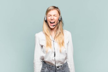 Genç sarışın tele pazarlamacı kadın agresif bir şekilde bağırıyor, çok kızgın, hayal kırıklığına uğramış, öfkeli ya da sinirli görünüyor, hayır diye bağırıyor.