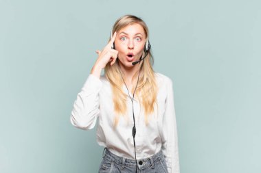 Genç sarışın tele pazarlamacı kadın şaşırmış, ağzı açık, şok olmuş, yeni bir düşünce, fikir ya da konsept keşfediyor.