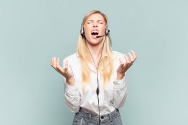 Genç sarışın tele pazarlamacı kadın umutsuz ve hayal kırıklığına uğramış, stresli, mutsuz ve sinirli, bağırıyor ve çığlık atıyor.