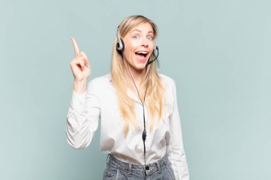 Genç sarışın tele pazarlamacı kadın bir fikri fark ettikten sonra mutlu ve heyecanlı bir dahi gibi hissediyor. Neşeli bir şekilde parmağını kaldırıyor.!