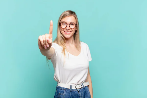 Joven Rubia Bonita Mujer Sonriendo Buscando Amigable Mostrando Número Uno —  Fotos de Stock