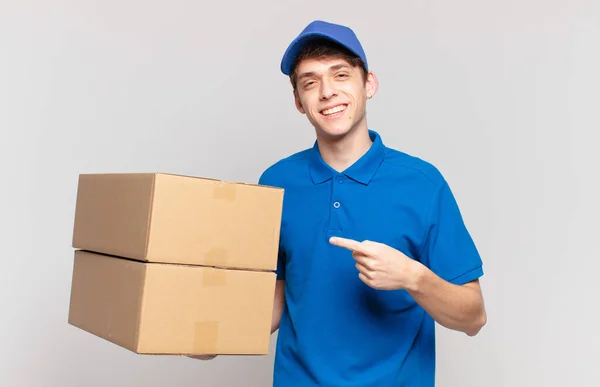 Pacote Jovem Entregar Menino Sorrindo Alegremente Sentindo Feliz Apontando Para — Fotografia de Stock