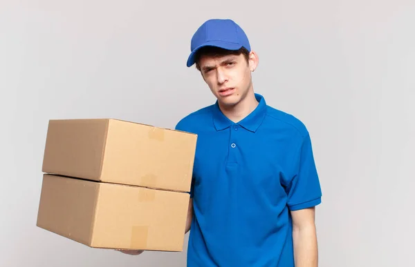 Young Package Deliver Boy Feeling Puzzled Confused Dumb Stunned Expression — Stok fotoğraf