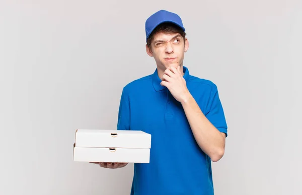 若いピザは 男の子の思考を提供します 疑問と混乱を感じます 別のオプションで どの意思決定を疑問に思います — ストック写真