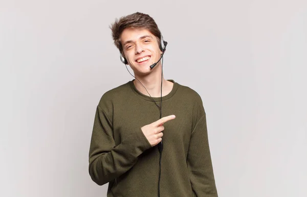 Young Telemarketer Smiling Cheerfully Feeling Happy Pointing Side Upwards Showing — Stock Photo, Image