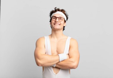 Komik sporcu adam kendini mutlu, gururlu ve umutlu hissediyor, merak ediyor ya da düşünüyor, çapraz kollarla boşluğu doldurmaya çalışıyor.