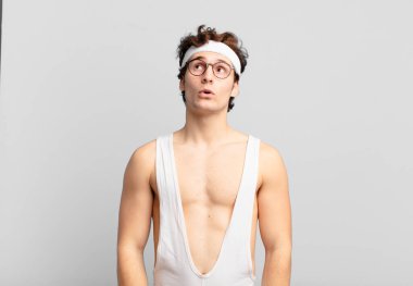 Endişeli, kafası karışık, budala bir ifadeyle mizahi bir sporcu, kopya alanı arıyor, şüphe ediyor.