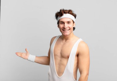 Komik sporcu kendini mutlu ve neşeli hissediyor, gülümsüyor ve seni selamlıyor, dostça bir jestle içeri davet ediyor.