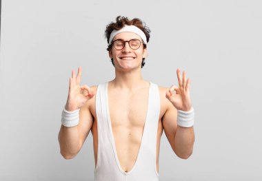 humorous sport man looking concentrated and meditating, feeling satisfied and relaxed, thinking or making a choice