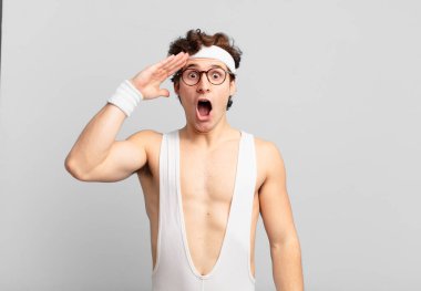 humorous sport man looking happy, astonished and surprised, smiling and realizing amazing and incredible good news