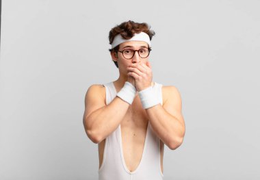 humorous sport man feeling ill with a sore throat and flu symptoms, coughing with mouth covered