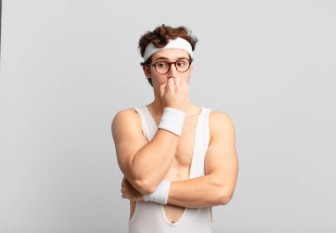 humorous sport man feeling serious, thoughtful and concerned, staring sideways with hand pressed against chin