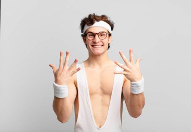 humorous sport man smiling and looking friendly, showing number ten or tenth with hand forward, counting down