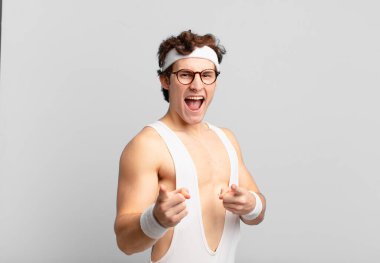 humorous sport man feeling happy, cool, satisfied, relaxed and successful, pointing at camera, choosing you