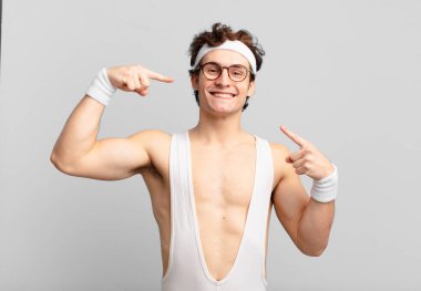 humorous sport man smiling confidently pointing to own broad smile, positive, relaxed, satisfied attitude