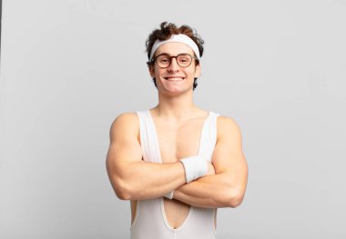 humorous sport man looking like a happy, proud and satisfied achiever smiling with arms crossed