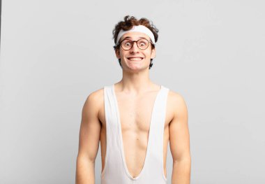 humorous sport man looking happy and goofy with a broad, fun, loony smile and eyes wide open