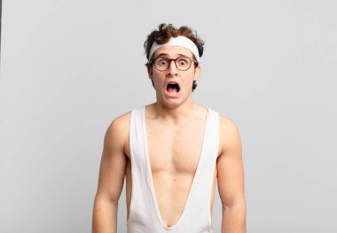 humorous sport man feeling terrified and shocked, with mouth wide open in surprise