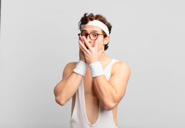 humorous sport man feeling scared or embarrassed, peeking or spying with eyes half-covered with hands