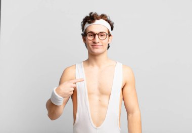 humorous sport man looking proud, confident and happy, smiling and pointing to self or making number one sign