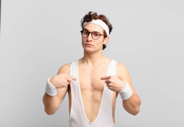 humorous sport man looking proud, positive and casual pointing to chest with both hands