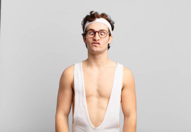 humorous sport man looking goofy and funny with a silly cross-eyed expression, joking and fooling around