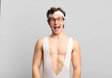 humorous sport man looking happy and pleasantly surprised, excited with a fascinated and shocked expression