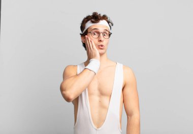 humorous sport man feeling shocked and astonished holding face to hand in disbelief with mouth wide open