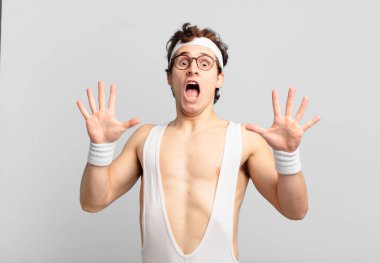 humorous sport man feeling stupefied and scared, fearing something frightening, with hands open up front saying stay away