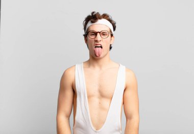 humorous sport man feeling disgusted and irritated, sticking tongue out, disliking something nasty and yucky