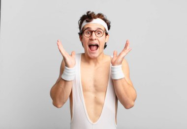 humorous sport man feeling shocked and excited, laughing, amazed and happy because of an unexpected surprise