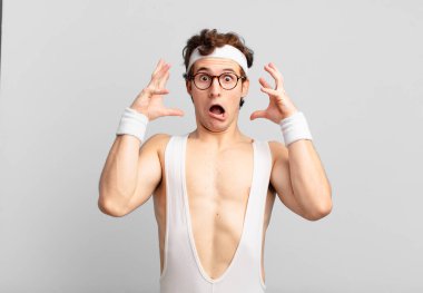 humorous sport man screaming with hands up in the air, feeling furious, frustrated, stressed and upset