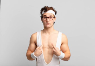 humorous sport man pointing to self with a confused and quizzical look, shocked and surprised to be chosen