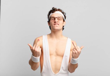 humorous sport man feeling provocative, aggressive and obscene, flipping the middle finger, with a rebellious attitude