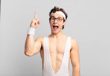 humorous sport man feeling like a happy and excited genius after realizing an idea, cheerfully raising finger, eureka!