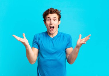 young sport boy feeling happy, excited, surprised or shocked, smiling and astonished at something unbelievable