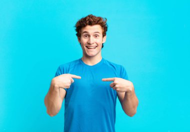 young sport boy feeling happy, surprised and proud, pointing to self with an excited, amazed look