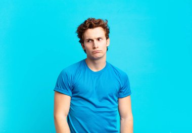 Genç sporcu çocuk üzgün, üzgün ya da kızgın ve olumsuz bir tavır takınıyor, anlaşmazlıkla kaşlarını çatıyor.