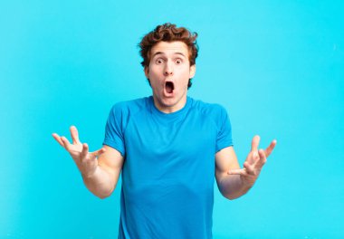 Genç sporcu çocuk, ağzı açık ve şaşırmış, şok olmuş ve hayrete düşmüş.