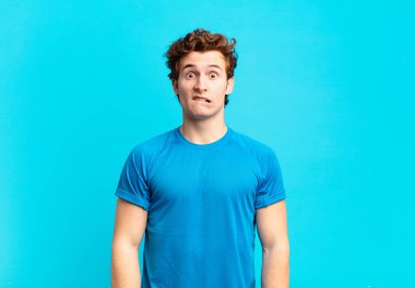 Genç sporcu çocuk şaşkın ve şaşkın görünüyor. Sinirli bir hareketle dudağını ısırıyor. Sorunun cevabını bilmiyor.