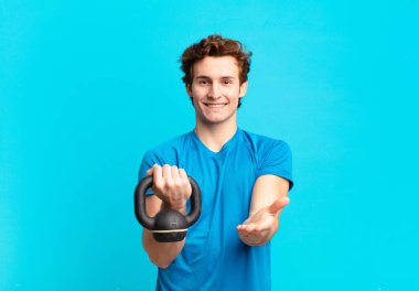 Genç sporcu çocuk güler yüzlü, arkadaş canlısı, kendine güvenen, olumlu bakışlı, bir nesne ya da konsept sunan ve gösteren. dambıl konsepti