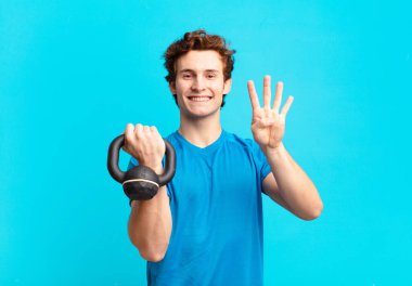 Genç sporcu çocuk gülümsüyor ve arkadaş canlısı görünüyor, dört ya da dört numarayı gösteriyor, eli önde, geriye doğru sayıyor. dambıl konsepti