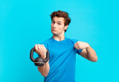 Genç sporcu çocuk kibirli, başarılı, pozitif ve gururlu görünüyor, kendini gösteriyor. dambıl konsepti