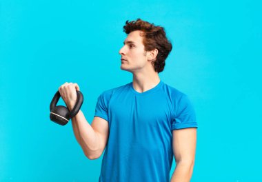 Profildeki genç sporcu çocuk uzayı kopyalamaya çalışıyor, düşünüyor, hayal ediyor ya da hayal kuruyor. dambıl konsepti