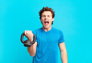 Genç sporcu çocuk agresif bir şekilde bağırıyor, kızgın, sinirli, öfkeli ya da sinirli görünüyor, hayır diye bağırıyor. dambıl konsepti